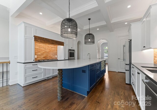 1108 Shinnecock Ln, Waxhaw, NC 28173 - kitchen featuring appliances with stainless steel finishes, arched walkways, blue cabinets, white cabinetry, and decorative backsplash