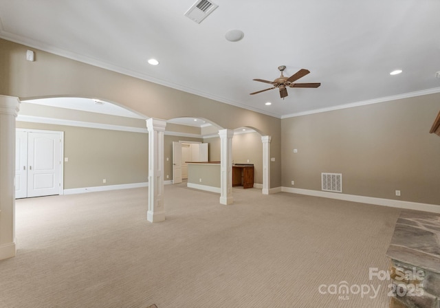 1108 Shinnecock Ln, Waxhaw, NC 28173 - unfurnished living room featuring decorative columns, a ceiling fan, recessed lighting, arched walkways, and light colored carpet
