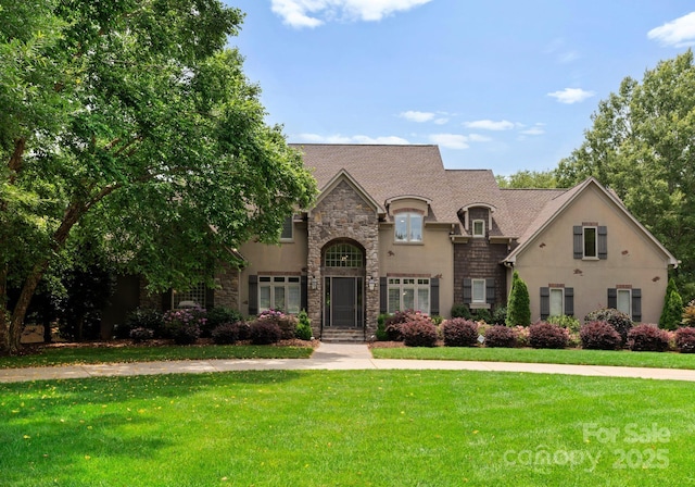 1108 Shinnecock Ln, Waxhaw, NC 28173 - french country inspired facade with stone siding, a front lawn, and stucco siding
