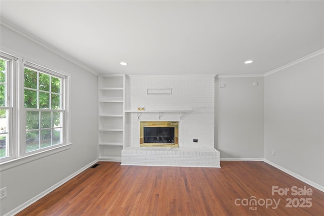 2011 Hampton Heights St, Lenoir, NC 28645 - unfurnished living room with baseboards, wood finished floors, a brick fireplace, recessed lighting, and crown molding