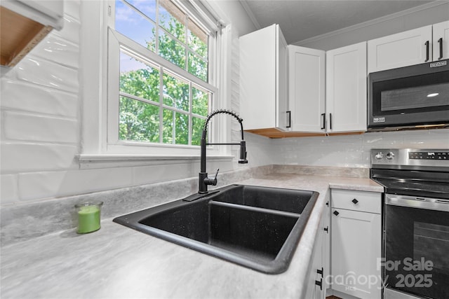 2011 Hampton Heights St, Lenoir, NC 28645 - kitchen with black microwave, stainless steel electric range, a sink, white cabinets, and ornamental molding