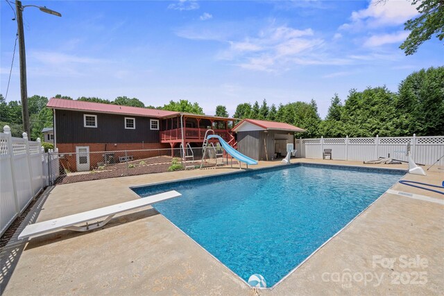 2011 Hampton Heights St, Lenoir, NC 28645 - view of swimming pool with a water slide, a diving board, a fenced backyard, and a patio area