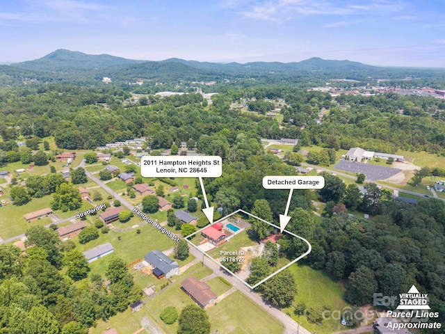 2011 Hampton Heights St, Lenoir, NC 28645 - aerial view of property and surrounding area with a mountain backdrop, property parcel outlined, and a heavily wooded area