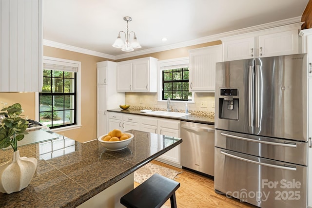 212 Riva Ridge Dr, Fairview, NC 28730 - kitchen with appliances with stainless steel finishes, tile counters, a sink, healthy amount of natural light, and crown molding