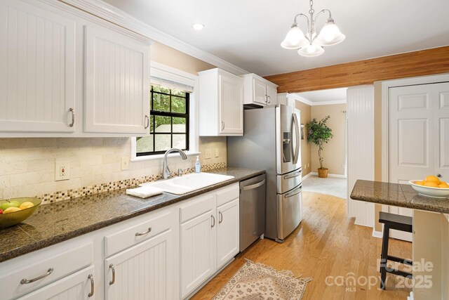 212 Riva Ridge Dr, Fairview, NC 28730 - kitchen featuring appliances with stainless steel finishes, a sink, ornamental molding, white cabinetry, and decorative backsplash