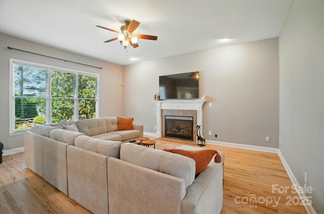 129 N Audubon Ave, Mooresville, NC 28117 - living room featuring ceiling fan, light wood finished floors, and a tiled fireplace