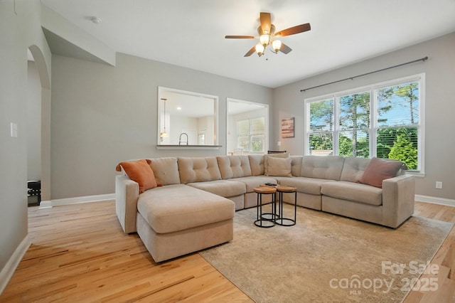 129 N Audubon Ave, Mooresville, NC 28117 - living room with light wood finished floors, ceiling fan, and arched walkways