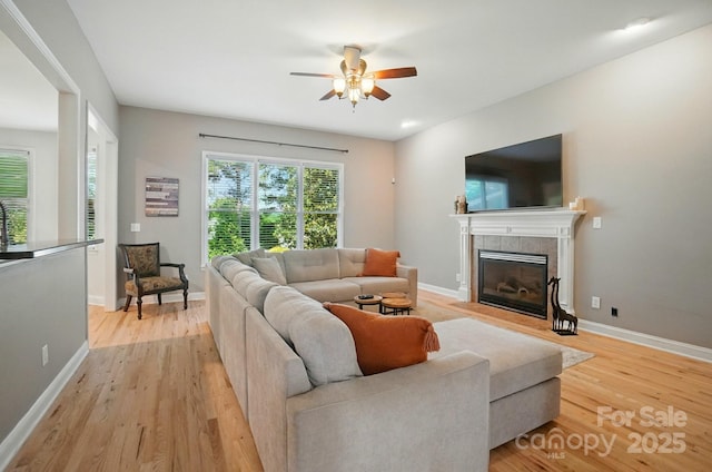 129 N Audubon Ave, Mooresville, NC 28117 - living room featuring a ceiling fan, light wood-style flooring, and a tiled fireplace