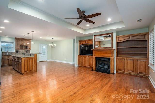 2817 Long Cir Unit 1, Iron Station, NC 28080 - unfurnished living room with a ceiling fan, a chandelier, a fireplace with flush hearth, light wood-type flooring, and baseboards