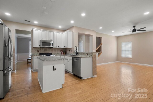 4764 Brockton Ct NW, Concord, NC 28027 - kitchen featuring stainless steel appliances, a center island, a sink, open floor plan, and ceiling fan