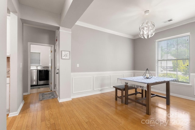 4764 Brockton Ct NW, Concord, NC 28027 - dining area featuring washer and clothes dryer, a chandelier, light wood-style flooring, and ornamental molding