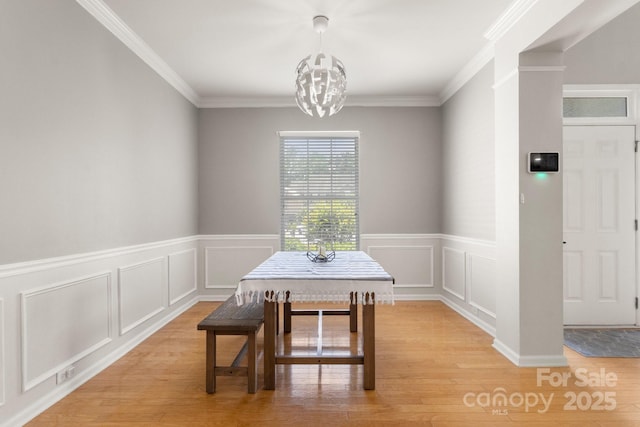 4764 Brockton Ct NW, Concord, NC 28027 - dining room with light wood-style flooring, a chandelier, wainscoting, ornamental molding, and a decorative wall