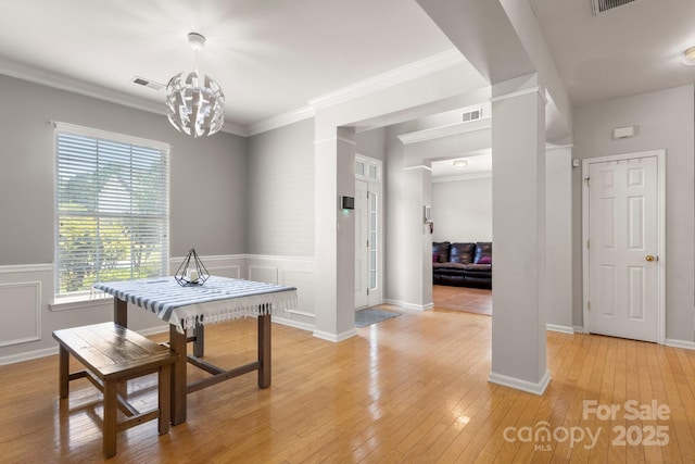 4764 Brockton Ct NW, Concord, NC 28027 - dining space with light wood-style floors, a chandelier, ornate columns, and ornamental molding