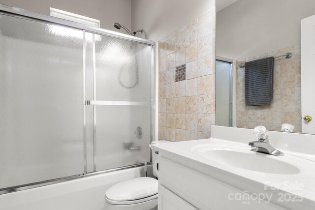 4764 Brockton Ct NW, Concord, NC 28027 - full bath featuring vanity, tile walls, toilet, and combined bath / shower with glass door