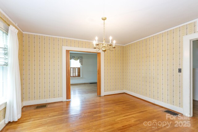 761 Milton Ave, Rock Hill, SC 29730 - spare room featuring healthy amount of natural light, wood finished floors, a chandelier, wallpapered walls, and baseboards
