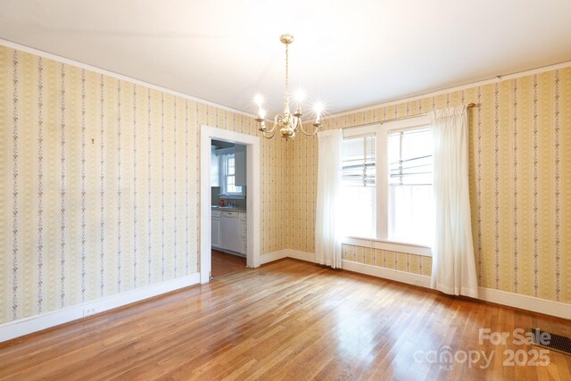 761 Milton Ave, Rock Hill, SC 29730 - unfurnished room with wood finished floors, a chandelier, baseboards, and wallpapered walls