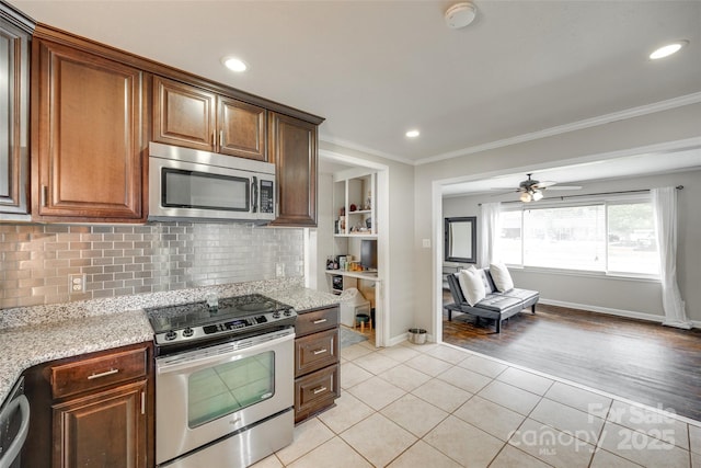 739 Springdale Rd, Rock Hill, SC 29730 - kitchen featuring appliances with stainless steel finishes, light tile patterned floors, crown molding, backsplash, and light stone countertops
