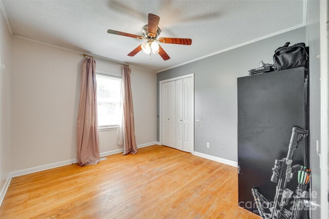 739 Springdale Rd, Rock Hill, SC 29730 - unfurnished bedroom with light wood finished floors, crown molding, a textured ceiling, a ceiling fan, and a closet