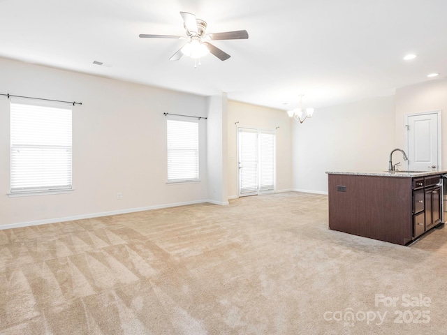 709 Volta Dr NW, Concord, NC 28027 - unfurnished living room featuring a chandelier, a sink, light carpet, a ceiling fan, and recessed lighting