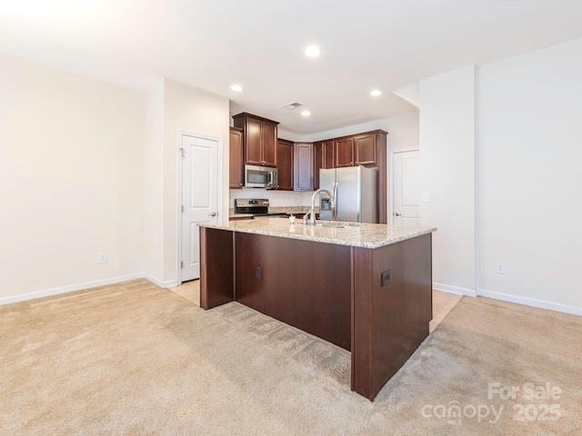 709 Volta Dr NW, Concord, NC 28027 - kitchen featuring appliances with stainless steel finishes, light carpet, baseboards, a center island with sink, and recessed lighting
