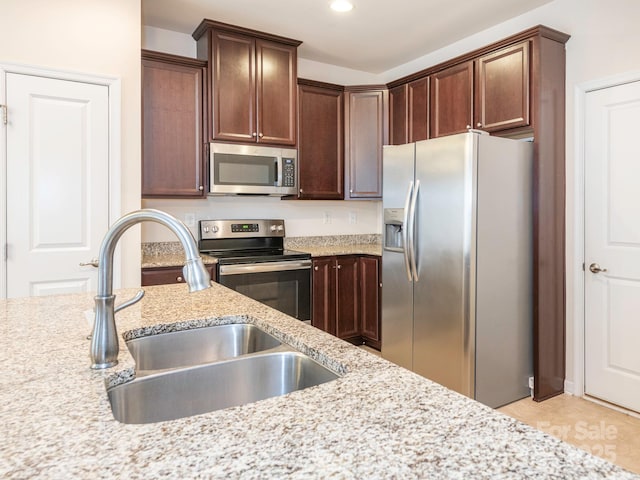 709 Volta Dr NW, Concord, NC 28027 - kitchen featuring stainless steel appliances, a sink, light stone counters, recessed lighting, and dark brown cabinets
