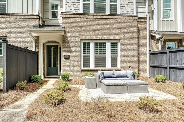 10022 Wayfair Meadow Ct, Charlotte, NC 28277 - doorway to property featuring an outdoor living space, brick siding, a patio area, and board and batten siding