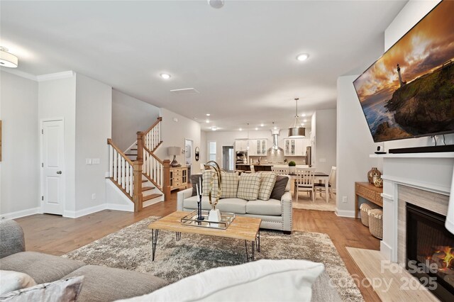 10022 Wayfair Meadow Ct, Charlotte, NC 28277 - living room with stairway, light wood-style floors, a fireplace with flush hearth, baseboards, and recessed lighting
