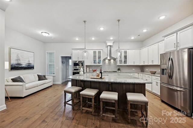 10022 Wayfair Meadow Ct, Charlotte, NC 28277 - kitchen with stainless steel refrigerator with ice dispenser, wall chimney range hood, tasteful backsplash, white cabinetry, and recessed lighting