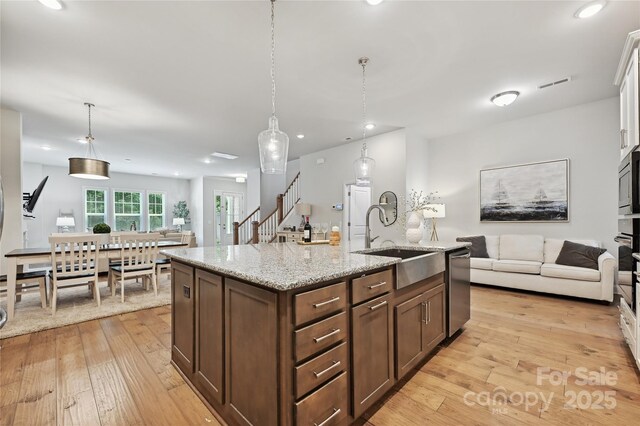 10022 Wayfair Meadow Ct, Charlotte, NC 28277 - kitchen featuring a sink, light wood-style floors, open floor plan, stainless steel dishwasher, and recessed lighting
