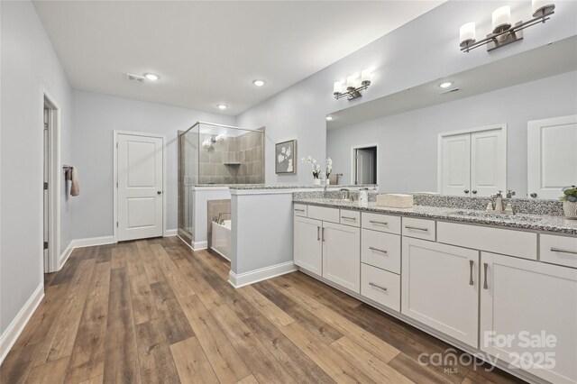 10022 Wayfair Meadow Ct, Charlotte, NC 28277 - bathroom with a stall shower, double vanity, a bath, baseboards, and wood finished floors