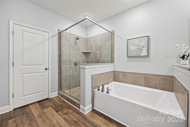 10022 Wayfair Meadow Ct, Charlotte, NC 28277 - full bathroom with a garden tub, a stall shower, and wood finished floors
