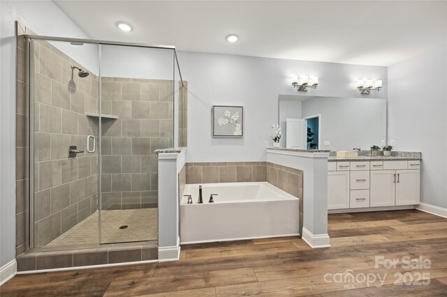 10022 Wayfair Meadow Ct, Charlotte, NC 28277 - bathroom featuring a garden tub, wood finished floors, a shower stall, vanity, and recessed lighting
