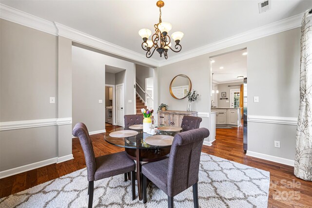 12312 Mcallister Park Dr, Charlotte, NC 28277 - dining area with wood finished floors, a chandelier, stairs, crown molding, and baseboards