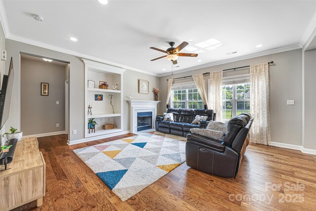 12312 Mcallister Park Dr, Charlotte, NC 28277 - living area featuring ceiling fan, baseboards, wood finished floors, crown molding, and built in shelves