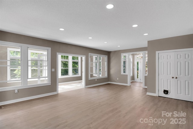 3333 Roberta Rd, Concord, NC 28027 - unfurnished living room featuring a chandelier, wood finished floors, recessed lighting, and a textured ceiling