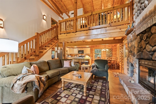 536 Tawodi Trl, Maggie Valley, NC 28751 - living room with a stone fireplace, high vaulted ceiling, light wood-type flooring, stairway, and a chandelier