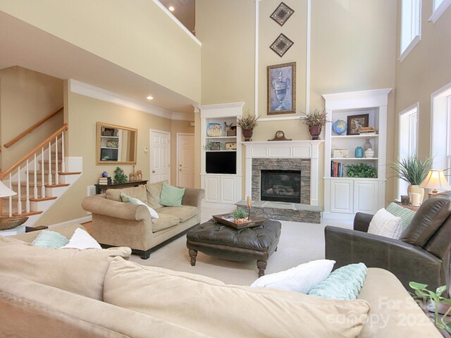 155 Culpeze Rd, Mooresville, NC 28117 - carpeted living room featuring a high ceiling, stairs, a stone fireplace, ornamental molding, and built in features