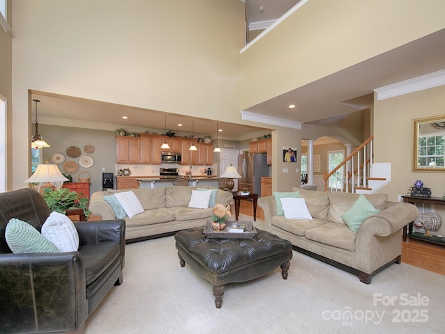 155 Culpeze Rd, Mooresville, NC 28117 - living area with arched walkways, ornamental molding, a towering ceiling, stairs, and ornate columns