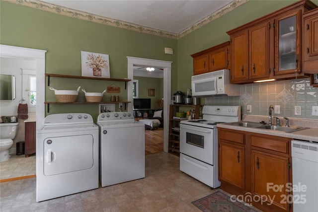 6 Wood Ave, Asheville, NC 28803 - kitchen with white appliances, washing machine and dryer, brown cabinetry, a sink, and light countertops