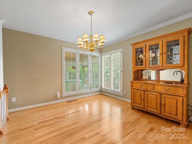 5104 Top Seed Ct, Charlotte, NC 28226 - unfurnished dining area with a chandelier, light wood-style floors, and crown molding