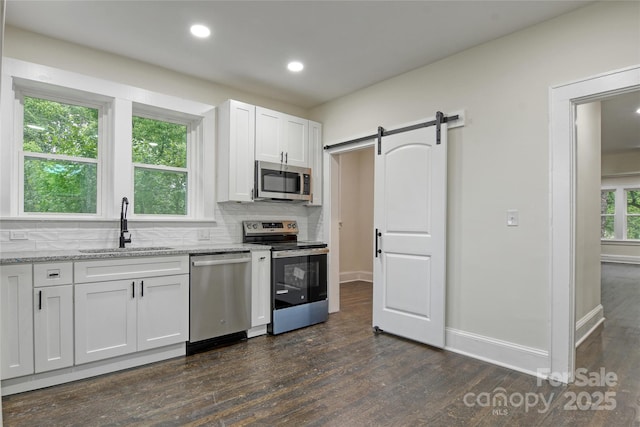 1783 Radio Station Rd, Newton, NC 28658 - kitchen with stainless steel appliances, a sink, dark wood-type flooring, backsplash, and a barn door