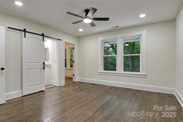 1783 Radio Station Rd, Newton, NC 28658 - unfurnished bedroom featuring a barn door, baseboards, dark wood-type flooring, and recessed lighting