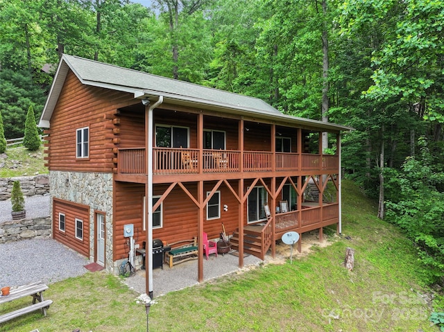 314 Prosperity Rdg, Waynesville, NC 28785 - rear view of property featuring a patio area, a view of trees, stone siding, and a deck