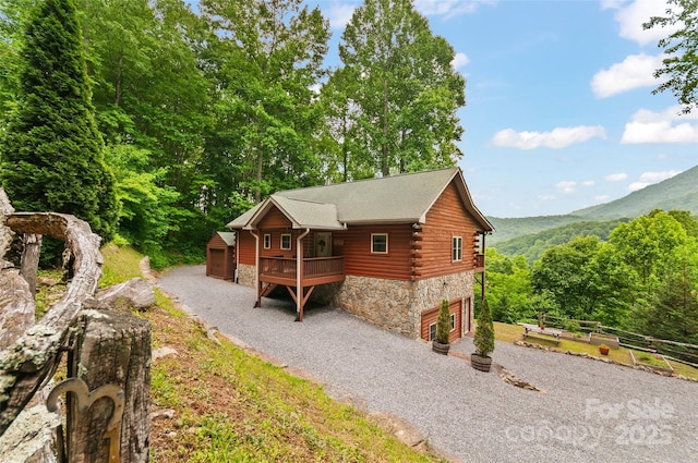 314 Prosperity Rdg, Waynesville, NC 28785 - view of front of property with stone siding, gravel driveway, log siding, a mountain view, and an attached garage