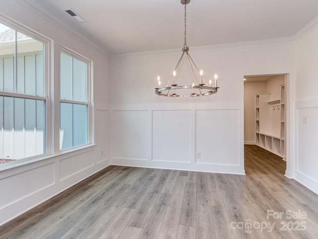 7108 Hambright Rd, Huntersville, NC 28078 - unfurnished dining area featuring a decorative wall, a chandelier, healthy amount of natural light, light wood-style flooring, and ornamental molding