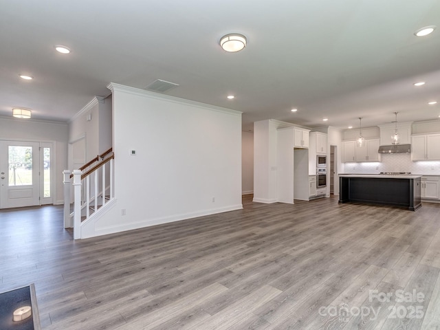 7108 Hambright Rd, Huntersville, NC 28078 - unfurnished living room with crown molding, recessed lighting, light wood-style flooring, baseboards, and stairs