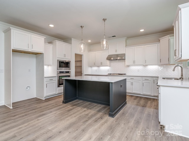 7108 Hambright Rd, Huntersville, NC 28078 - kitchen with a sink, under cabinet range hood, appliances with stainless steel finishes, a center island, and light wood-style flooring