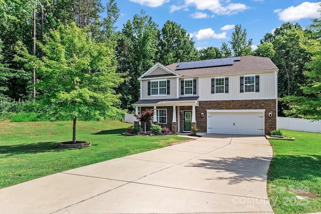 301 Wheat Field Dr, Mount Holly, NC 28120 - view of front facade with concrete driveway, a garage, roof mounted solar panels, covered porch, and stone siding