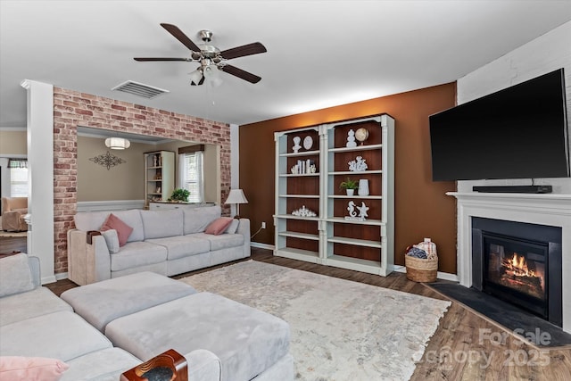 301 Wheat Field Dr, Mount Holly, NC 28120 - living room featuring a ceiling fan, a fireplace, wood finished floors, brick wall, and baseboards
