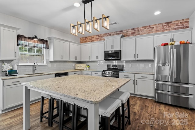 301 Wheat Field Dr, Mount Holly, NC 28120 - kitchen featuring stainless steel appliances, a sink, decorative backsplash, a breakfast bar area, and recessed lighting
